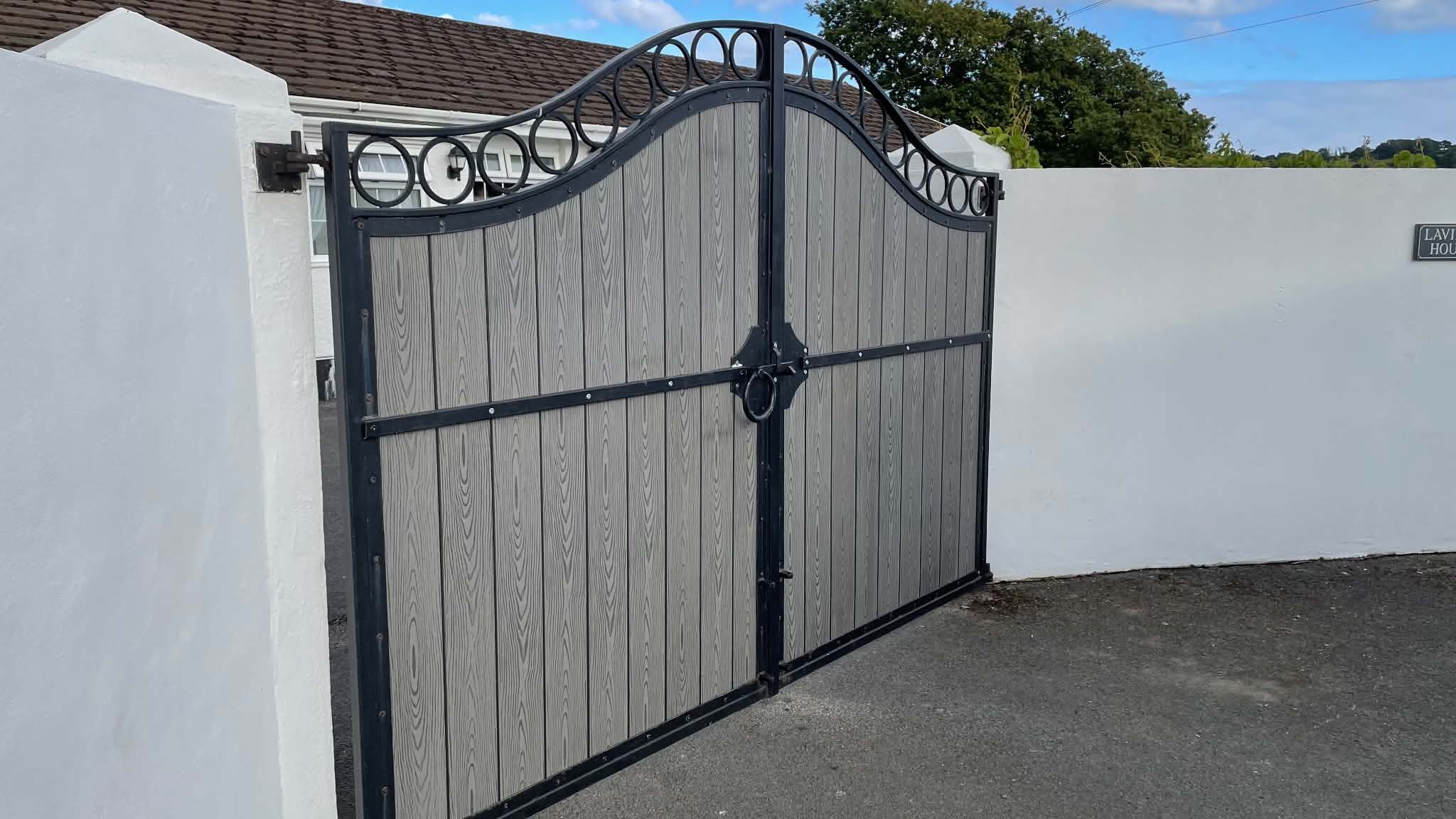 Bespoke composite driveway gates with decorative ironwork arch Wales